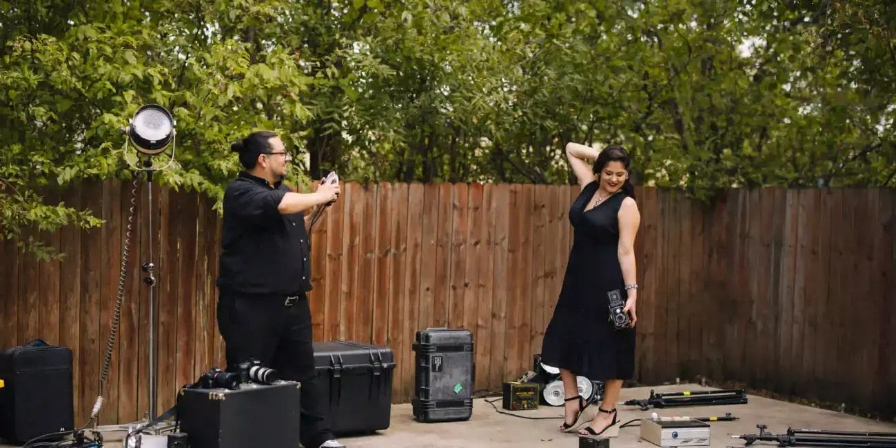 Danny and Rachel pose in a backyard filled with equipment, ready for an outdoor project.