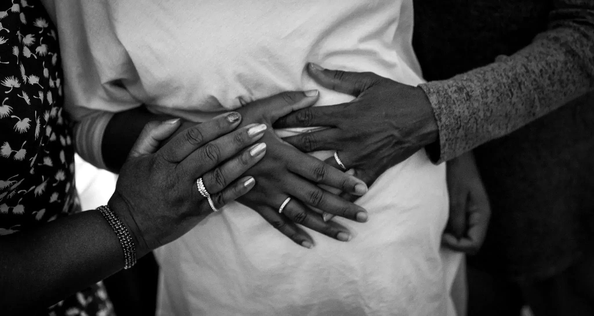 A black and white photo of a couple gently holding hands, symbolizing love and connection.
