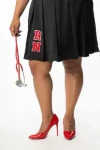 A person wearing a black skirt with red "RN" letters and red high heels holds a red stethoscope, standing against a white background.