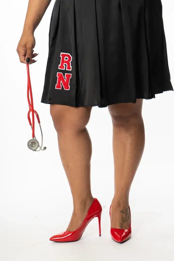 A person wearing a black skirt with red "RN" letters and red high heels holds a red stethoscope, standing against a white background.